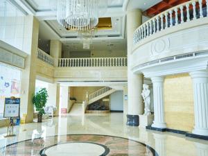 eine große Lobby mit einem Kronleuchter und einer Treppe in der Unterkunft Vienna Hotel Shenzhen Shajing Shangnan in Bao'an