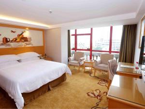 a hotel room with a bed and a large window at Vienna Hotel Zhongshan West District in Zhongshan