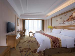a hotel room with a large bed and a television at Vienna International Hotel Foshan Beijiao New City Meidi Headquarter in Shunde
