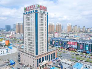 東営にあるVienna Hotel Dongying Taihangshan Roadの都心の白い高い建物