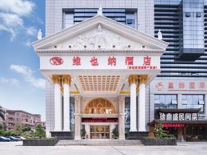 een gebouw met een groot wit gebouw met rode letters erop bij Vienna Hotel Dongguan Chengcaiyuan International Plaza in Dongguan