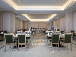 a dining room with tables and chairs in a restaurant at Vienna International Hotel (Jiaxing Nanhu Hotel) in Jiaxing