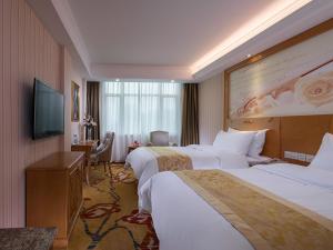 ein Hotelzimmer mit 2 Betten und einem Flachbild-TV in der Unterkunft Vienna Hotel (Jieyang Jinxian Dadao Shop) in Jieyang