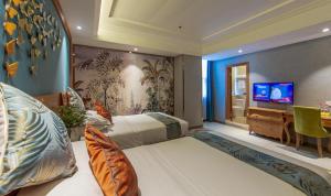a bedroom with two beds and a desk and a tv at Vienna 3 Best Hotel Chaozhou Ancient City in Chaozhou