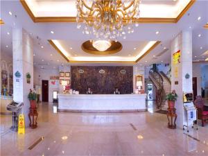 a large lobby with a chandelier in a building at Vienna Hotel Meizhou railway station in Meizhou