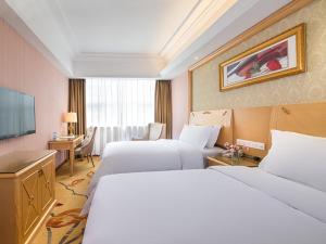 um quarto de hotel com duas camas e uma televisão em Vienna 3 Best Hotel Exhibition Center Chigang Road em Guangzhou