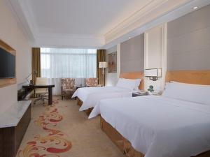 Postel nebo postele na pokoji v ubytování Vienna Hotel Jiangmen Heshan Huamao