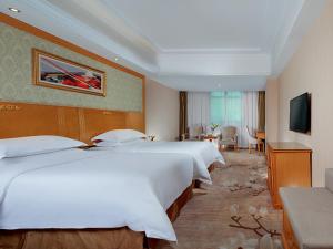 a hotel room with three beds and a television at Vienna Hotel Yueyang Zhanqian Road in Yueyang