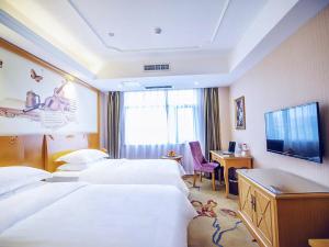 a hotel room with two beds and a desk at Vienna Hotel Anhui Mingzhu Square in Ershilipu