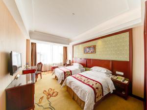 a hotel room with two beds and a television at Vienna Hotel Shanghai Jiading New City in Shanghai