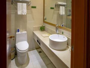 a bathroom with a sink and a toilet and a mirror at Vienna Hotel Shanghai Yangpu Wujiaochang in Shanghai