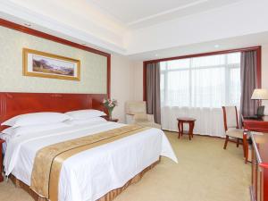 a hotel room with a large bed and a desk at Vienna Hotel Ningbo Ninghai in Shang-ts'un +3 photos
