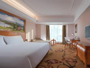 Cette chambre comprend un grand lit et un bureau. dans l'établissement Vienna Hotel (Danxia Mountain Scenic Spot), à Renhua