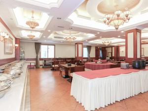 杭州市にあるVienna International Hotel - Hangzhou Wulin Square Branchのダイニングルーム(テーブル、椅子、シャンデリア付)