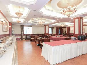 a dining room with tables and chairs and chandeliers at Vienna International Hotel - Hangzhou Wulin Square Branch in Hangzhou