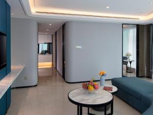 a living room with a blue couch and a table at Vienna Hotel(Haikou International Convention and Exhibition Center) in Haikou
