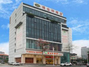 a tall white building with a sign on top of it at Vienna Hotel Shunde Longjia Exhibition Center in Shunde
