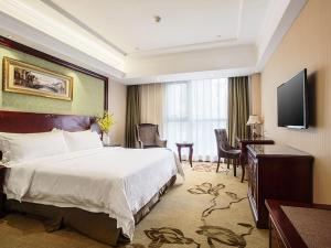 Nanchang County的住宿－维也纳酒店昌南客运站店，酒店客房配有一张床、一张书桌和一台电视。