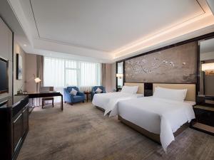a hotel room with two beds and a television at Vienna (Hunan Zhuzhou Chaling County) in Chaling