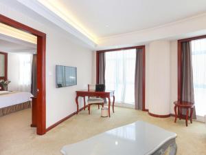 une chambre d'hôtel avec un bureau et un lit et une chambre dans l'établissement Vienna Hotel Ningbo Ninghai, à Shang-ts'un
