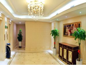 a large lobby with a chandelier and plants in it at Vienna International Hotel Meizhou Dingzi Bridge in Meizhou