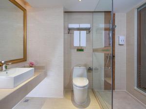 La salle de bains est pourvue de toilettes, d'un lavabo et d'une douche. dans l'établissement Vienna International Hotel Shenzhen Caopu Jindaotian, à Shenzhen