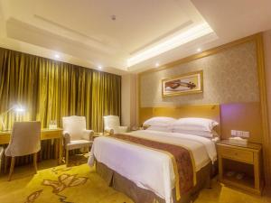 a hotel room with a large bed and a desk at Vienna Hotel Sanya Yalong Bay Qianguqing in Sanya