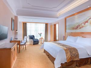 Vienna Hotel Yangjiang Jiangcheng District في يانغجيانغ: غرفه فندقيه سرير كبير وتلفزيون
