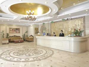a hotel lobby with two people sitting at a counter at Vienna Hotel Suzhou Luokou Metro Station in Suzhou