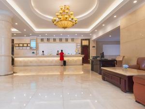 a person standing in a large lobby with a large room at Vienna Hotel Shenzhen Haiwan in Shenzhen