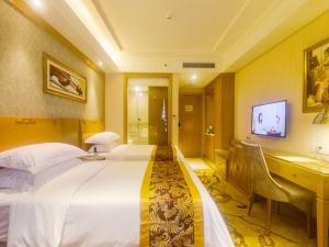 a hotel room with a large bed and a desk at Vienna Hotel Sanya Yalong Bay Qianguqing in Sanya