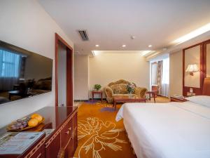 a hotel room with a bed and a living room at Vienna Hotel Foshan Chancheng Zumiao Branch in Foshan