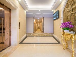 a hallway of a hotel with a console table and flowers at Vienna 3 Best Hotel Exhibition Center Chigang Road in Guangzhou