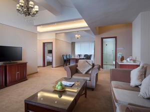 a living room with a couch and a tv at Vienna International Hotel Yangshuo West Street in Yangshuo