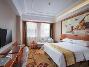 ein Hotelzimmer mit einem großen Bett und einem Flachbild-TV in der Unterkunft Vienna Hotel(Rugao Auto Station Branch) in Rugao