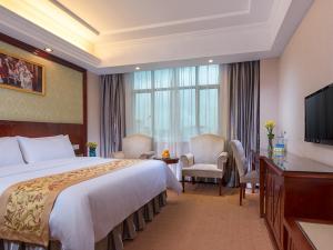 a hotel room with a large bed and a television at Vienna Hotel Guangzhou Airport 2 in Guangzhou