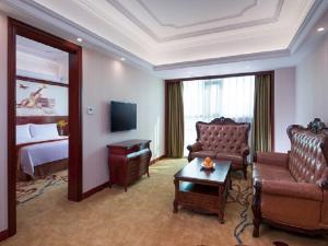a hotel room with a couch and a bed at Vienna International Hotel Heyuan Yajule Garden in Heyuan