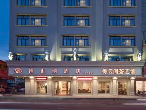 Um edifício com escritos asiáticos na parte da frente. em Vienna Hotel Qingyuan Yingde Guangming Road em Yingde