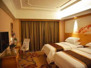 una camera d'albergo con due letti e una televisione di Vienna International Hotel Xuancheng Garden a Xuanzhou
