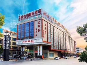 un bâtiment dont l'écriture est sur son côté dans l'établissement Vienna International Hotel Guangzhou Changlong Qifu Xincun, à Canton