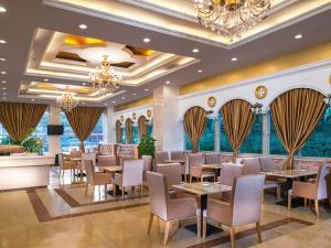 un ristorante con tavoli, sedie e lampadario a braccio di Vienna Hotel Shenzhen Yousong Branch a Bao'an