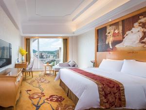 a hotel room with a large bed and a large window at Vienna International Hotel Hunan Chenzhou Qingnian Avenue in Chenzhou