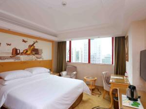 a hotel room with a large white bed and windows at Vienna Hotel Zhongshan West District in Zhongshan