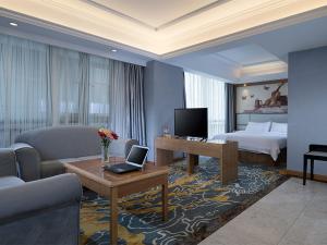 een hotelkamer met een bed en een laptop op een tafel bij Vienna Hotel Dongguan East Bus Station in Dongguan