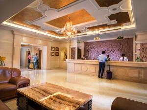 a man standing at a counter in a hotel lobby at Vienna Hotel Shenzhen Fenghuang Road in Shenzhen