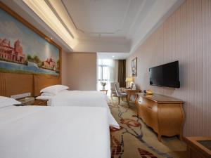 Vienna International Hotel Fuzhou Cangshan Wanda في فوتشو: غرفة فندقية بسريرين وتلفزيون بشاشة مسطحة