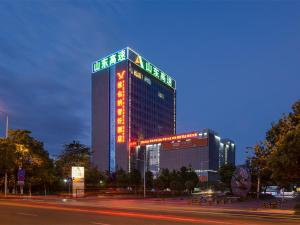 a large building with a sign on it at night at Vienna Hotel Kunming North Caiyun Road Asia in Kunming