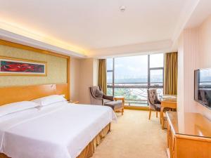 pokój hotelowy z dużym łóżkiem i dużym oknem w obiekcie Vienna Hotel Guangzhou Panyu Dashi Qiao w Guangzhou