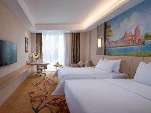 Habitación de hotel con 3 camas y TV en Vienna International Hotel (Guangdong Yunfu Emerging New City Plaza Store), en Dongkou