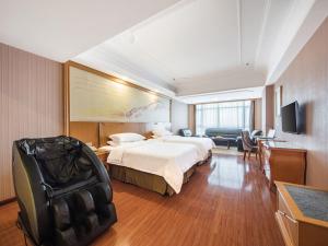 a hotel room with a large bed and a television at Vienna Hotel Hunan Hengyang Railway Station in Hengyang